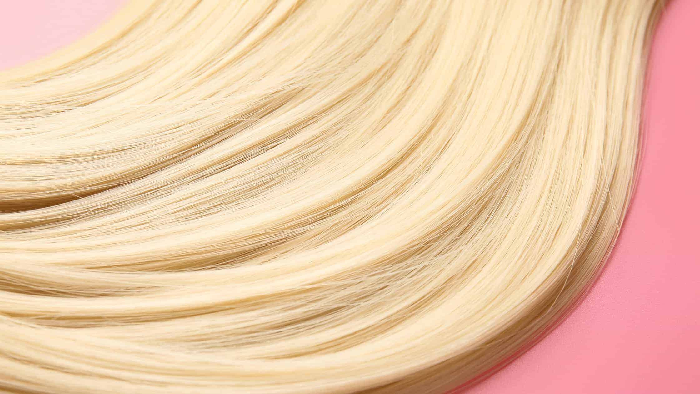 Close-up van glanzend blond steil haar, effect van plantaardige keratine