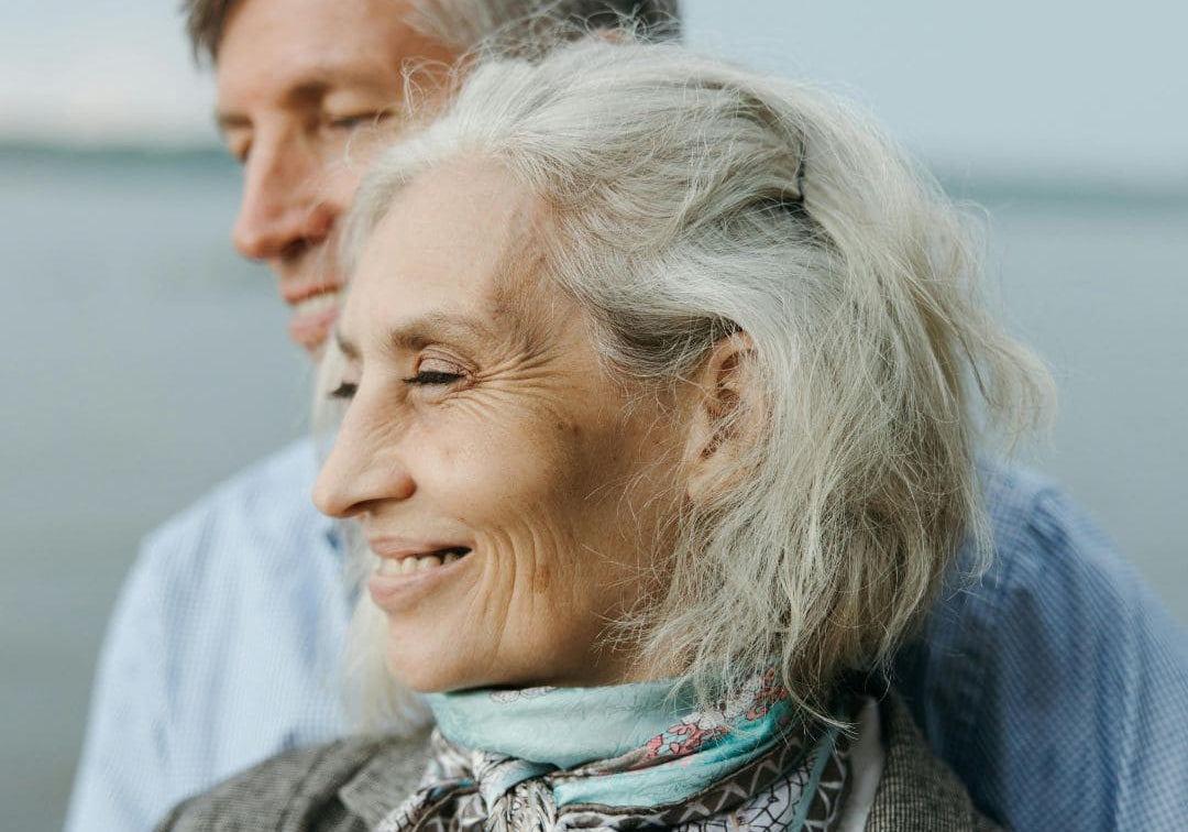 Ouder echtpaar bij het water, de vrouw heeft wit haar